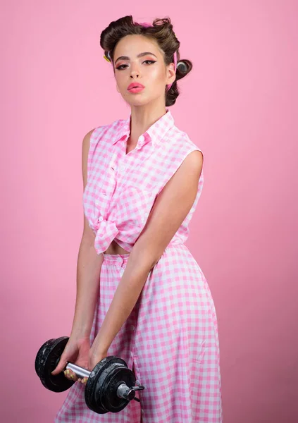 powerful housewife. pinup girl with fashion hair. retro woman with dumbbell. Sport. pin up woman with trendy makeup. pretty girl in vintage style. womens power