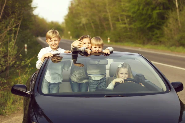 Счастливые дети друзья в машине — стоковое фото