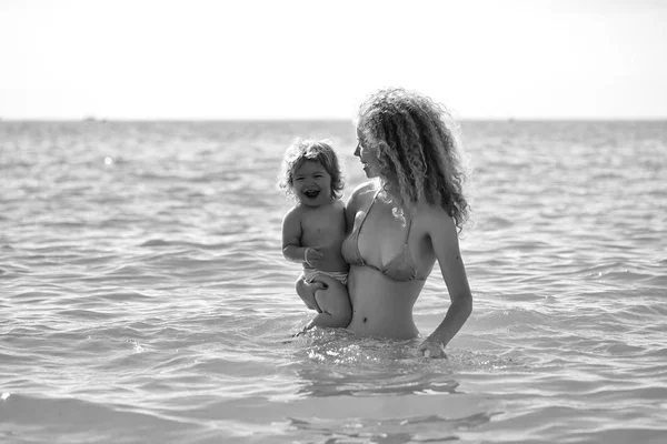 Vrouw in bikini met kind — Stockfoto