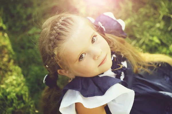 Happy cute girl with braid hair smiling on green grass — Stock Photo, Image