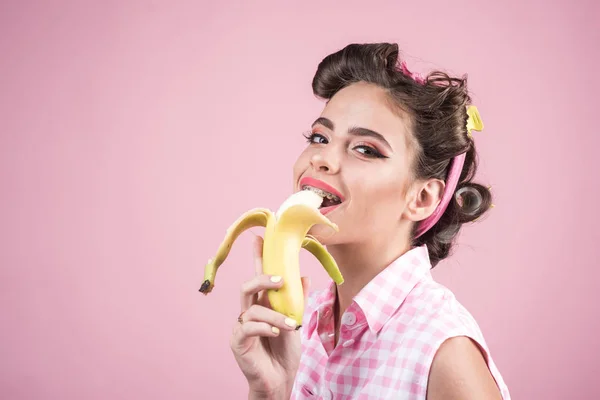 Девушка-пинап с модными волосами. Подцепить женщину с модным макияжем. Банановая диета. женщина-ретро ест банан. красивая девушка в винтажном стиле, скопировать пространство. Так вкусно. — стоковое фото
