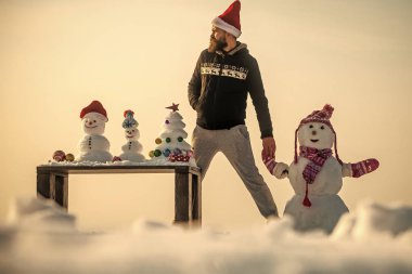 Adam ve kardan adam holding eller üzerinde beyaz gökyüzü