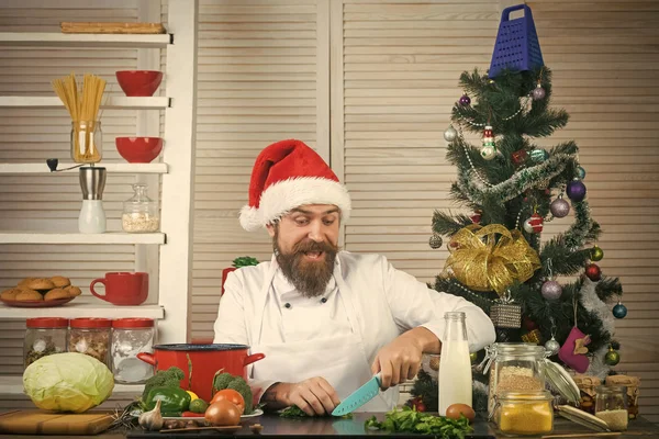 Chef man in santa claus hat cooking. — Stock Photo, Image