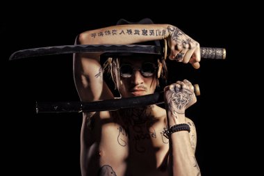 Adam kılıç dövmeli eller, boyun ve göğüs ile poz