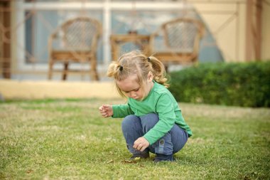 Yaprakları ile oynayan erkek bebek.