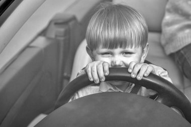 Cute boy pretends driving car clipart