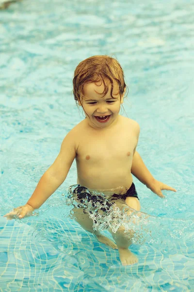 Bonito menino alegre tem banho na piscina exterior — Fotografia de Stock