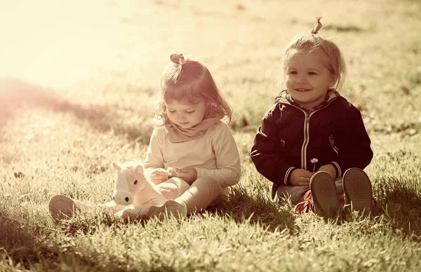 Niño y niña recoger flores en la hierba verde —  Fotos de Stock