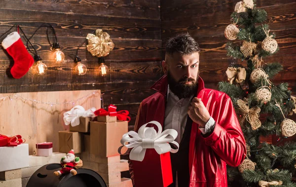 Hipster jultomte med nyår presenterar. Hem jul dekoration och nyår bakgrund. Santa claus håll röd jul presentbox. — Stockfoto