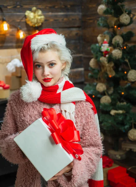 Happy new year. Beautiful Woman with christmas box gif at Home. Beauty Model Girl in Santa Hat on home design decorate. Holly jolly swag Christmas and noel. Emotions. — Stock Photo, Image