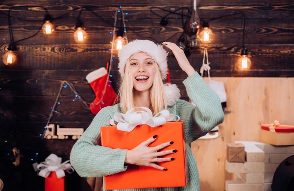 Πορτραίτο μιας νεαρής γυναίκας χαμογελαστά. Holly jolly κλοπιμαία Χριστούγεννα και noel. Δώρο το νέο έτος. Χριστούγεννα εσωτερικό. Ομορφιά κορίτσι μοντέλο στο καπέλο Santa στο σχεδιασμό σπίτι διακοσμούν. — Φωτογραφία Αρχείου