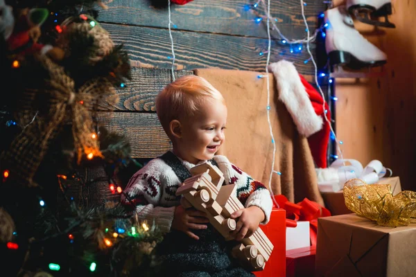 Kinder haben Spaß in der Nähe des Weihnachtsbaums drinnen. Kindergeschenk. Weihnachtskinder. Christbaumschmuck. Winterkinder. — Stockfoto