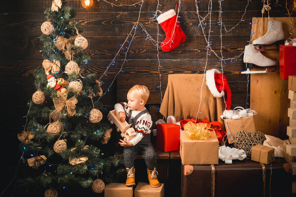 Merry Christmas and Happy New year. Babies. Portrait kid with gift on wooden background. Happy child with christmas gift box. Cheerful cute child opening a Christmas present.