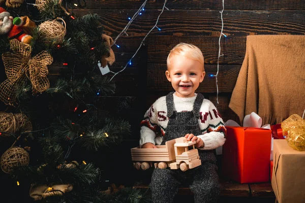Retrato de criança feliz olhando para bola de brinquedo decorativo pela árvore de Natal. Feliz Natal. Miúdo a divertir-se perto da árvore de Natal dentro de casa. Crianças, Natal. Na manhã anterior ao Natal . — Fotografia de Stock