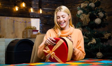 Aralık sürpriz ve parti zamanı. Noel hediyesi olan kadın Noel ağacı önünde kutuları. İfadeler yüz. Mutlu Noeller ve mutlu yeni yıl