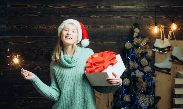 Retrato de una joven sonriente. Jovencita alegre vistiendo traje de Navidad sobre la pared de madera. Mujer hermosa con gif caja de Navidad en casa. Emoción feliz . — Foto de Stock