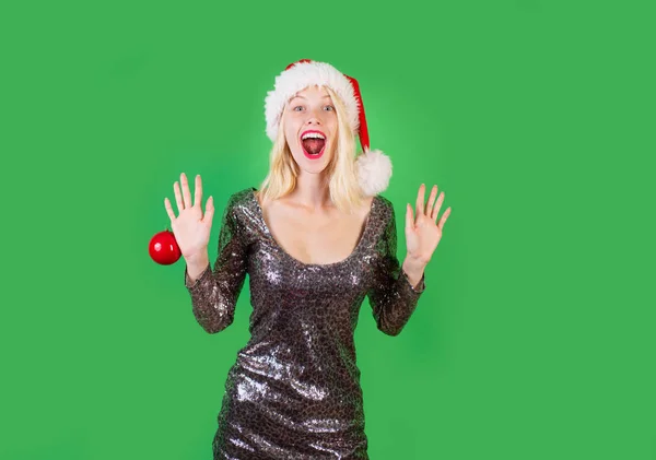 Funny girl in santa clause costume. Fashion portrait of girl. Sensual girl for Christmas. Beauty Model Girl in Santa Hat on green Background isolated. Cheerful young woman wearing christmas costume