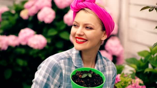 Mujer sonriente y feliz se preocupa por las flores. Concepto de cuidado y cultivo de flores . — Vídeo de stock