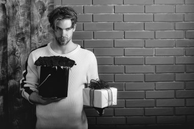 sakallı adam tutar kırmızı gül çiçek ve hediye kutusu