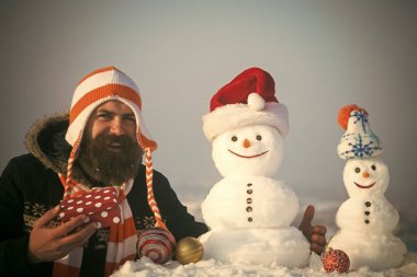 Kardan adam Noel Baba şapkalı ile gülümseyen adam