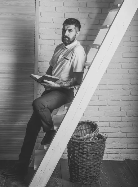 Homem barbudo ou hipster ler livro na escada — Fotografia de Stock