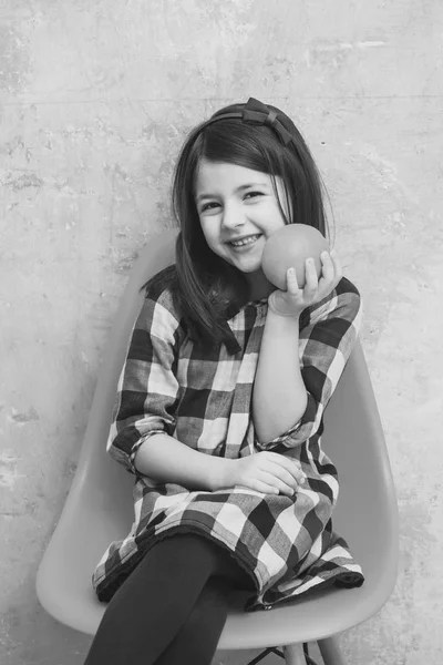 Menina feliz com sorriso bonito e laranja na mão sorrindo — Fotografia de Stock