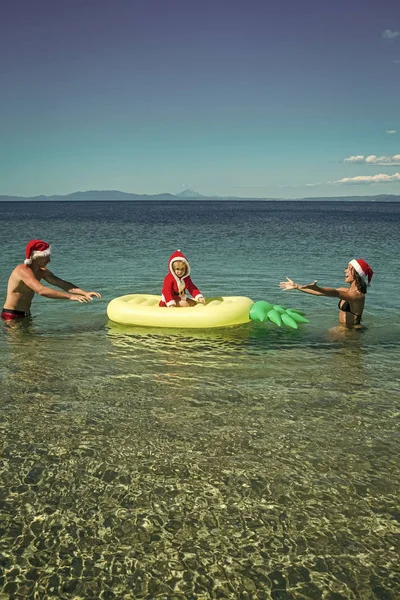 Natal família feliz no colchão de abacaxi na água . — Fotografia de Stock