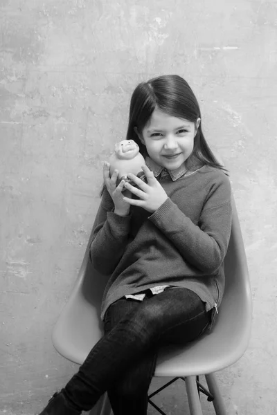 Criança ou sorrindo, menina bonito segurando rosa porquinho banco — Fotografia de Stock