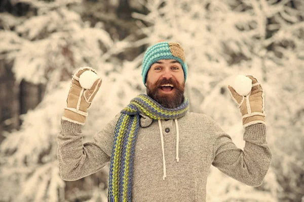 Vousatý muž úsměv s sněhové koule v zasněženém lese — Stock fotografie