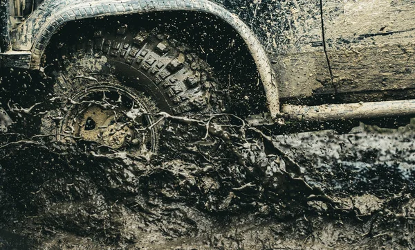 Fornire la migliore esperienza per il offroader. Auto da corsa fuoristrada. Ruote auto su terreno steppa spruzzi di sporcizia. Auto fuoristrada in azione. Auto sporca guidare ad alta velocità. SUV o fuoristrada su strada fangosa — Foto Stock