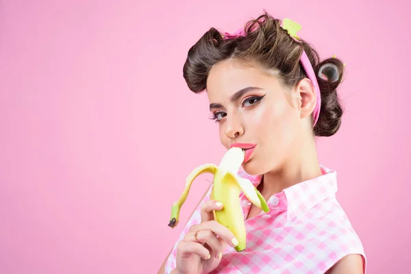Ładna dziewczyna w stylu vintage. upiąć kobieta z modnym makijażu. Dziewczyna Pinup moda włosów. banan dieta. retro kobieta jedzenie banana, miejsce. letnie owoce pocałunek — Zdjęcie stockowe