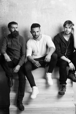 Üç yakışıklı erkekler ya da ahşap merdivenlerde oturan arkadaşlar