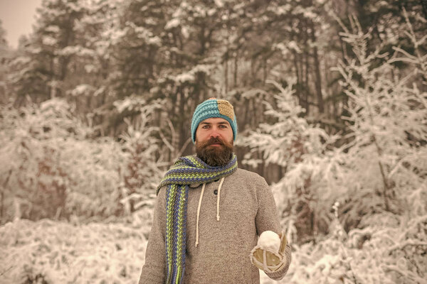 Bearded man with snowball in snowy forest