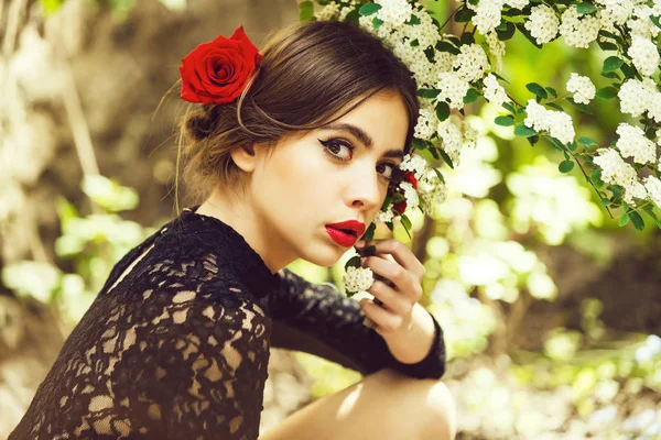 Ładna dziewczyna z czerwonymi ustami pozowanie z białych kwiatów kwitnących — Zdjęcie stockowe