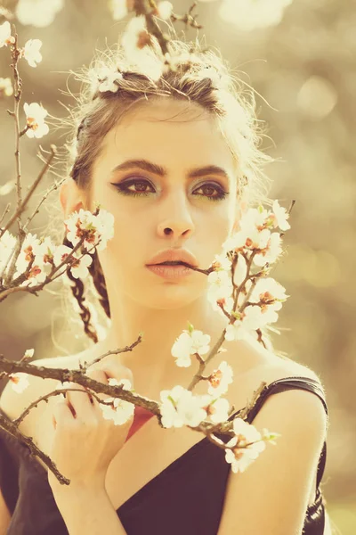 Chica bonita con maquillaje de moda entre flores de cerezo en flor de primavera — Foto de Stock