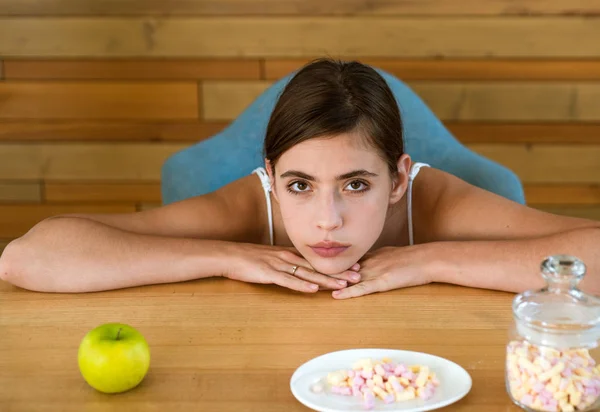 Besin seçimi. Kadın yemek ne yemek seçin. Güzel kadın bakmak elma ve Marshmallow. Organik ve doğal veya tatlı ve sağlıksız. Vitamin veya şeker. Diyet veya sağlıksız gıda — Stok fotoğraf