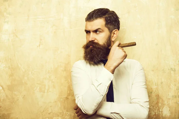 Бородатий чоловік на серйозному обличчі палить сигару — стокове фото