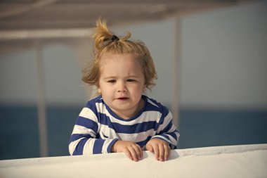 Küçük çocuk çocuk şirin ciddi yüzle gemide yelken