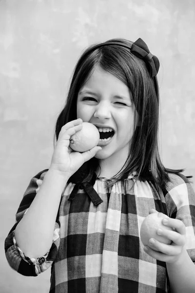 Bambino o ragazza con occhio ammiccante mangiare limoni — Foto Stock
