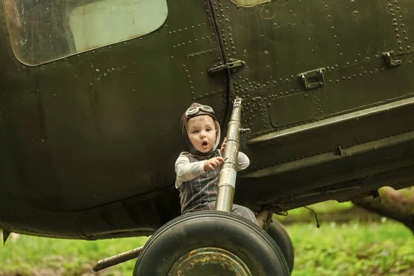 Boy in pilot helmet with glasses on green grass — Stock Photo, Image