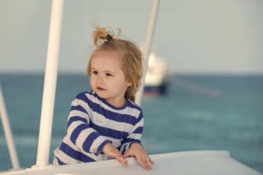 Mavi okyanus su almak çizgili gömlekli çocuk.