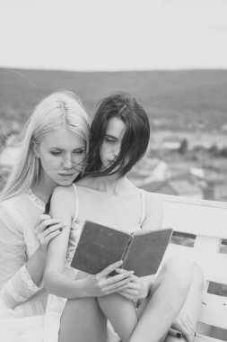 Doğal peyzaj üzerinde uzun saçlı sarışın ve esmer kadın