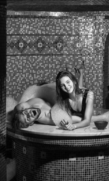 Homem muscular e mulher sexy deitado no banho com espuma — Fotografia de Stock