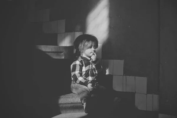 Criança com cara pensante sentar-se nas escadas da casa — Fotografia de Stock
