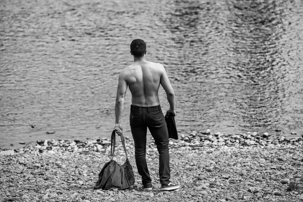 Gespierde man met de tas in de buurt van water — Stockfoto