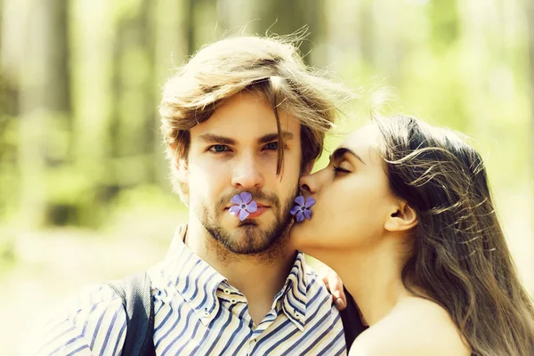 Женщина целует мужчину на естественном фоне — стоковое фото