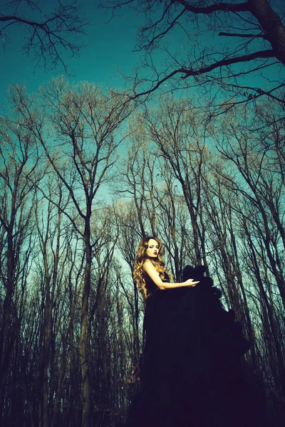 Elegante jonge vrouw in het bos — Stockfoto