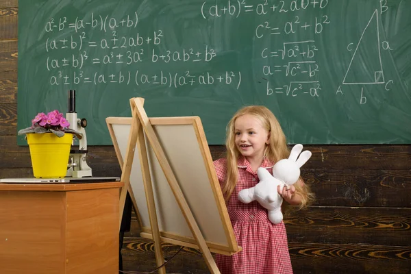 Детская картина на мольберте в художественной студии. Девочка учится рисовать картинку — стоковое фото