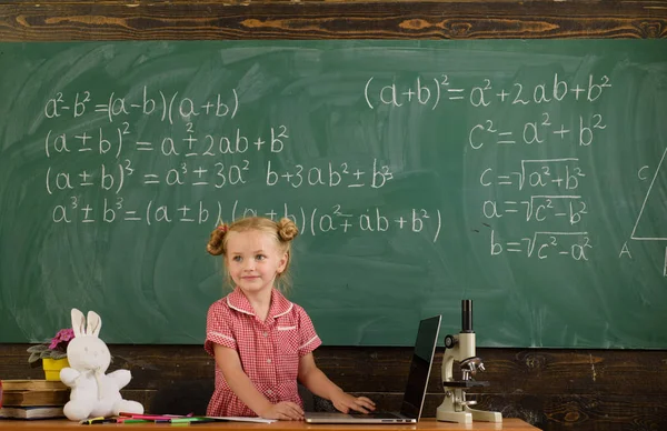 Маленька дівчинка вчиться використовувати комп'ютерні технології в класі. Освіта з новими технологіями в школі. Цифрові ваші — стокове фото