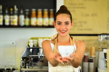 Mutlu ve sevimli. Barista fincan sıcak kahve içecek hizmet. Kadın barista kahve dükkanında. Güzel kadın stand Cafe tezgahın arkasındaki. Kafede kahve bira. En iyi kahve tarifi